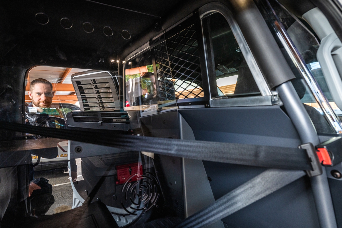 Man looking into the backseat area of a truck.